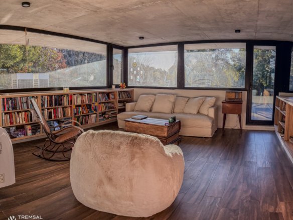 Living luminoso con biblioteca y vista al parque en una casa de country preparada para la venta