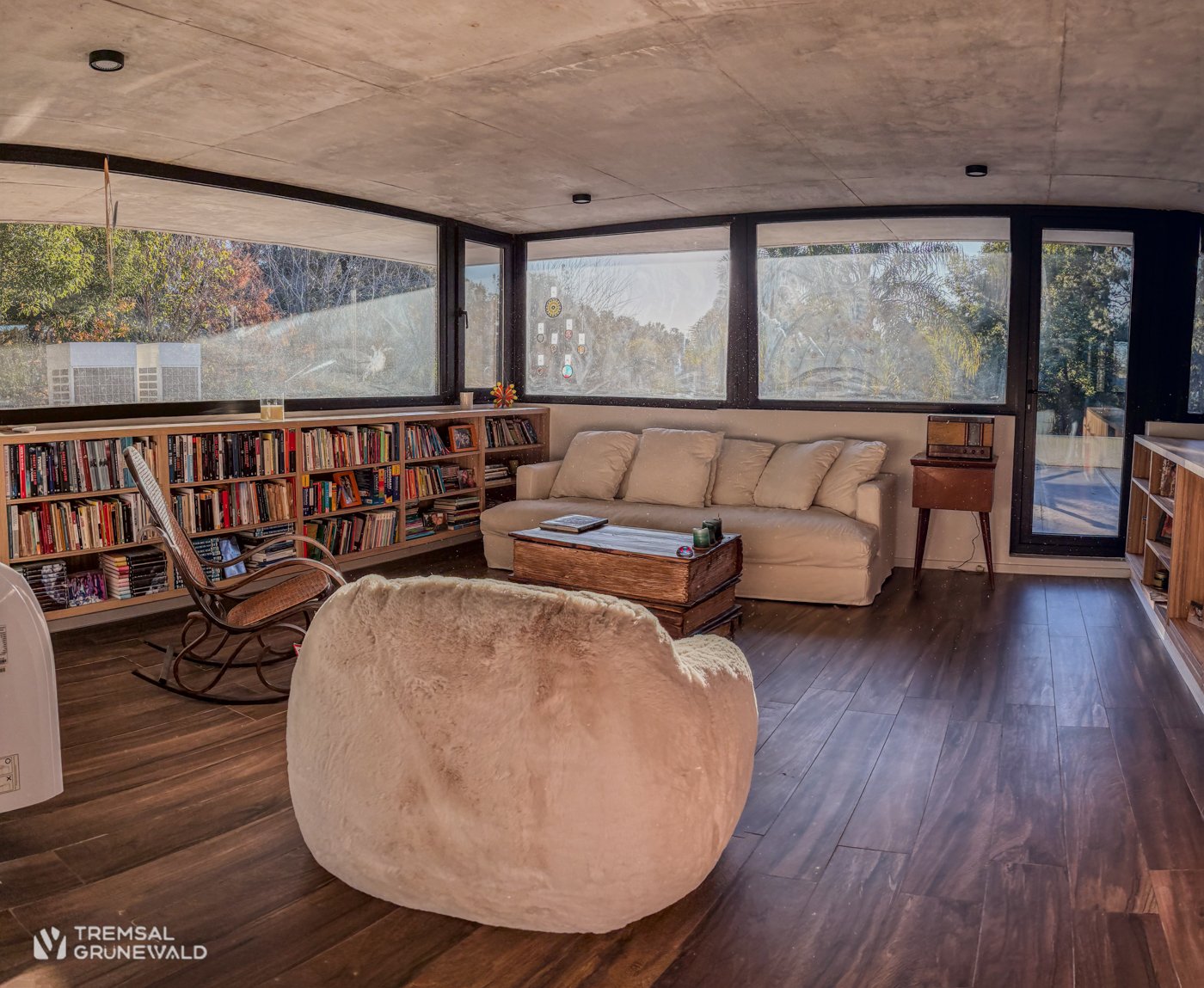 Living luminoso con biblioteca y vista al parque en una casa de country preparada para la venta