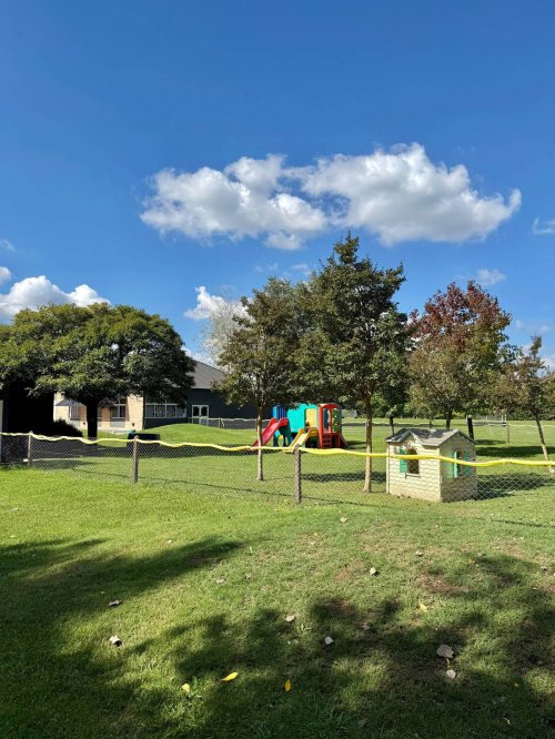 Jardín y área de juegos del Oakwood Bilingual School, uno de los colegios cerca de San Diego, con casita y juegos infantiles al aire libre